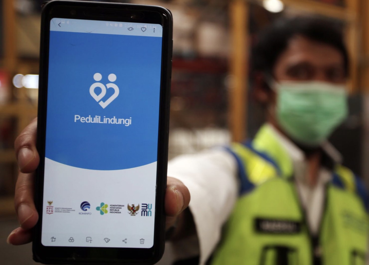 Seorang petugas kesehatan memperlihatkan aplikasi PeduliLindungi. (Foto: Kementerian Komunikasi dan Informatika).